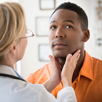 Doctor checking man's throat